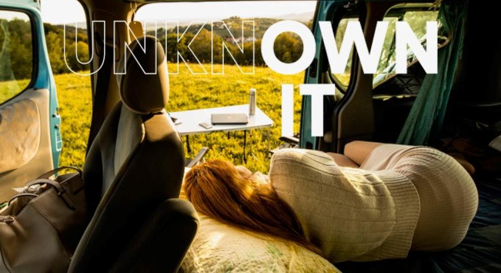 Woman lying in a campervan in a field