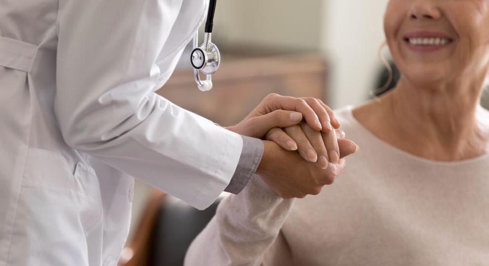 Doctor holding hands with a female patient